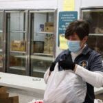 photo of Marie Wienckowski bagging items for distribution.