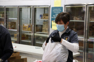 photo of Marie Wienckowski bagging items for distribution.